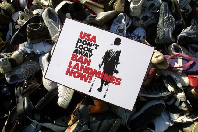 שלט איסור מוקשים מוצב על פירמידה שנערמה על ידי נעליים שנאספו בחודשים האחרונים על ידי הקמפיין האמריקאי לאיסור מוקשים.