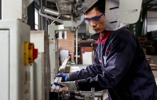 עובד שעובד על מוצרי אלומיניום במפעל בזאופינג שבמחוז שאנדונג שבמזרח סין