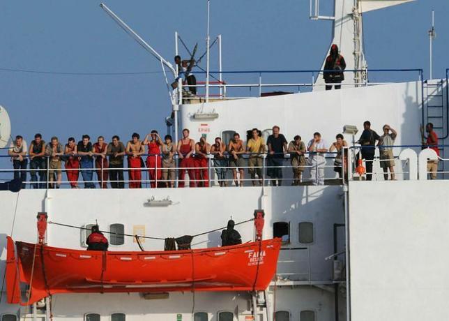 שודדי ים סומליים המחזיקים בספינת הסוחר, MV Faina, עומדים על סיפון הספינה עם אנשי הצוות ב-19 באוקטובר 2008.